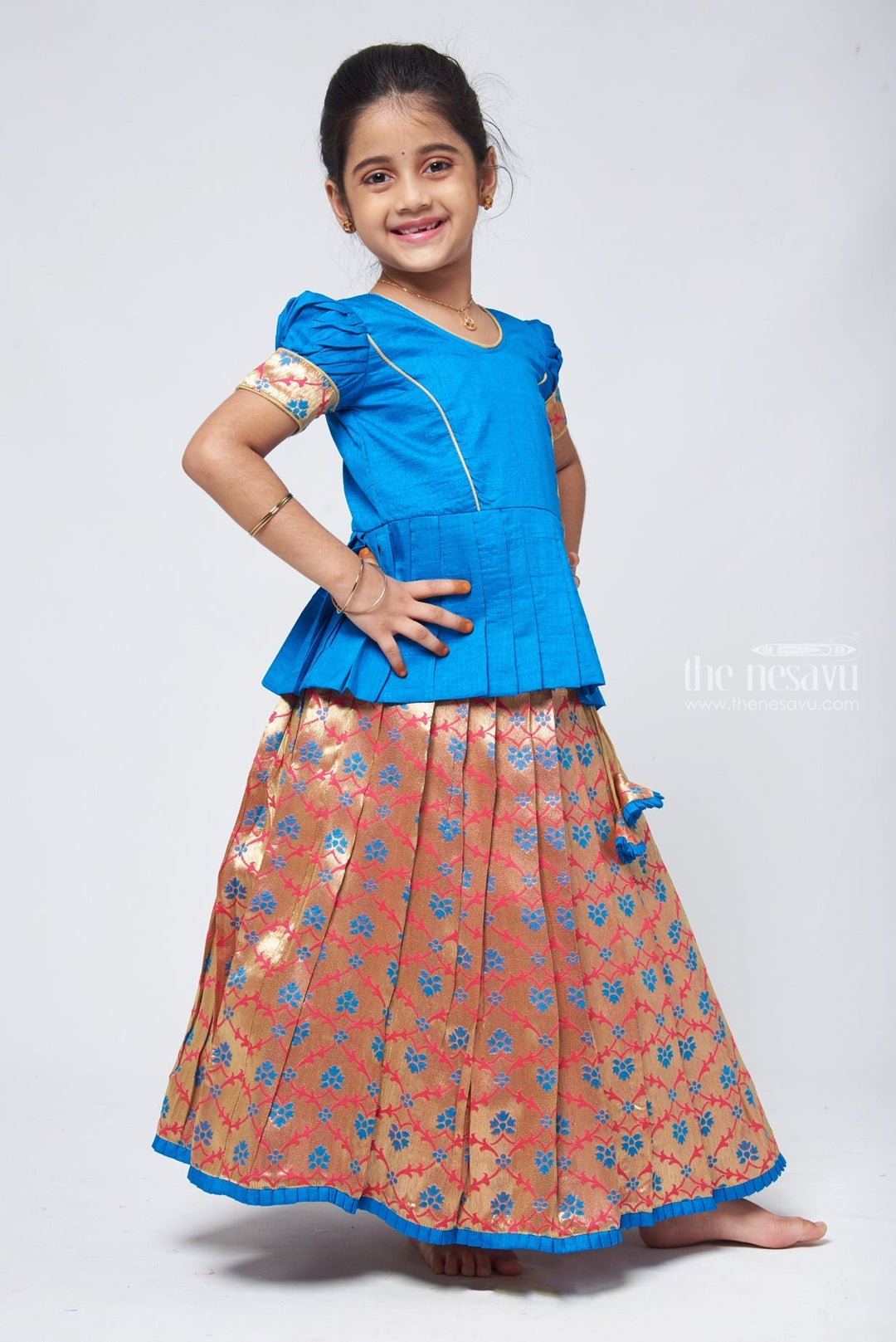 The Nesavu Pattu Pavadai Charming Blue Silk Peplum Blouse with Zari Floral Pattu Pavadai: Perfect Celebration Wear for Girls Nesavu Silk Blouse with Zari Floral Pattu Pavadai | Traditional Pattu Pavadai | The Nesavu