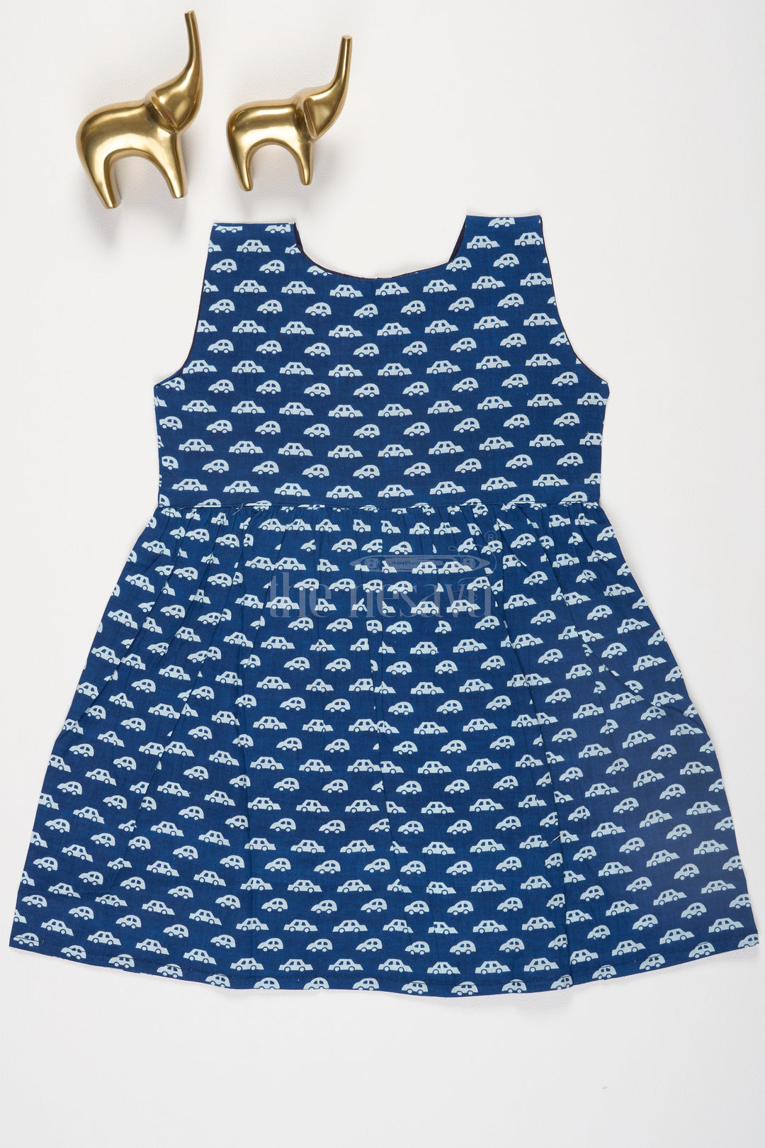 The Nesavu Baby Cotton Frocks Indigo Blue Cartoon Car Print Cotton Baby Frock with Mock Wrap Neck and Front Button Fastening Nesavu Indigo Blue Cartoon Car Print Cotton Baby Frock with Mock Wrap Neck Nesavu