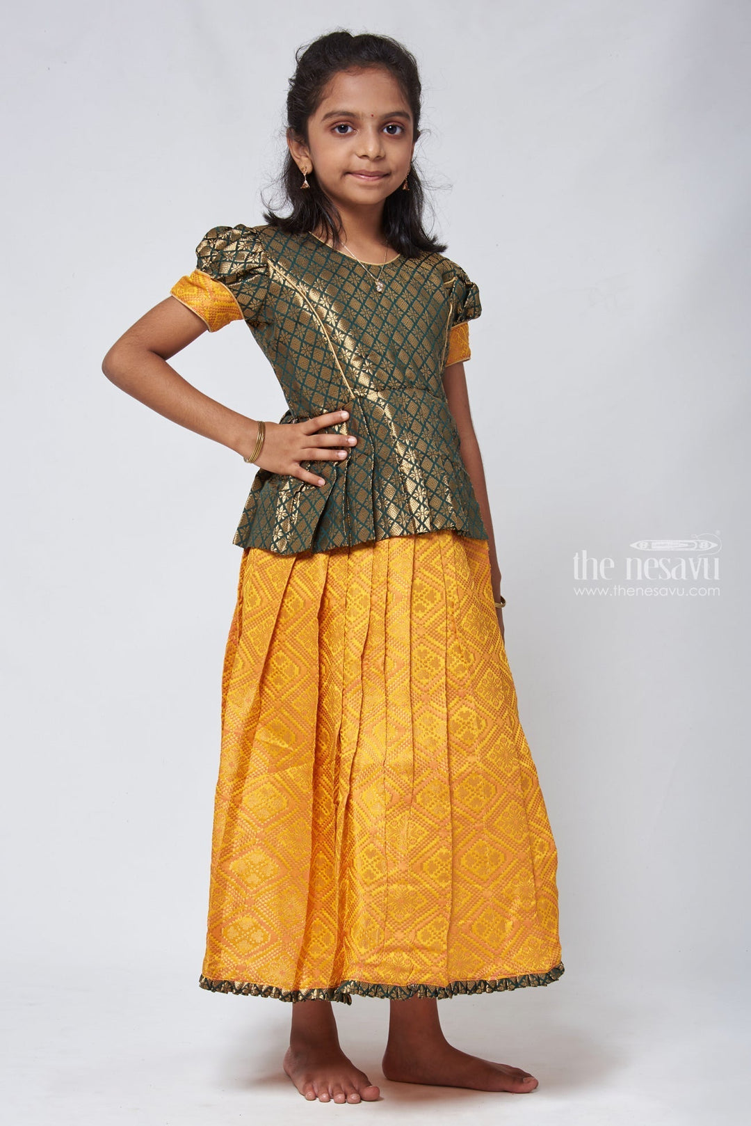 The Nesavu Pattu Pavadai Majestic Brocade Green Peplum Blouse paired with Patola Yellow Pattu Pavadai: Timeless South Indian Fashion Nesavu Pattu Pavadai with neck designs | Girls traditional silk dresses | The Nesavu