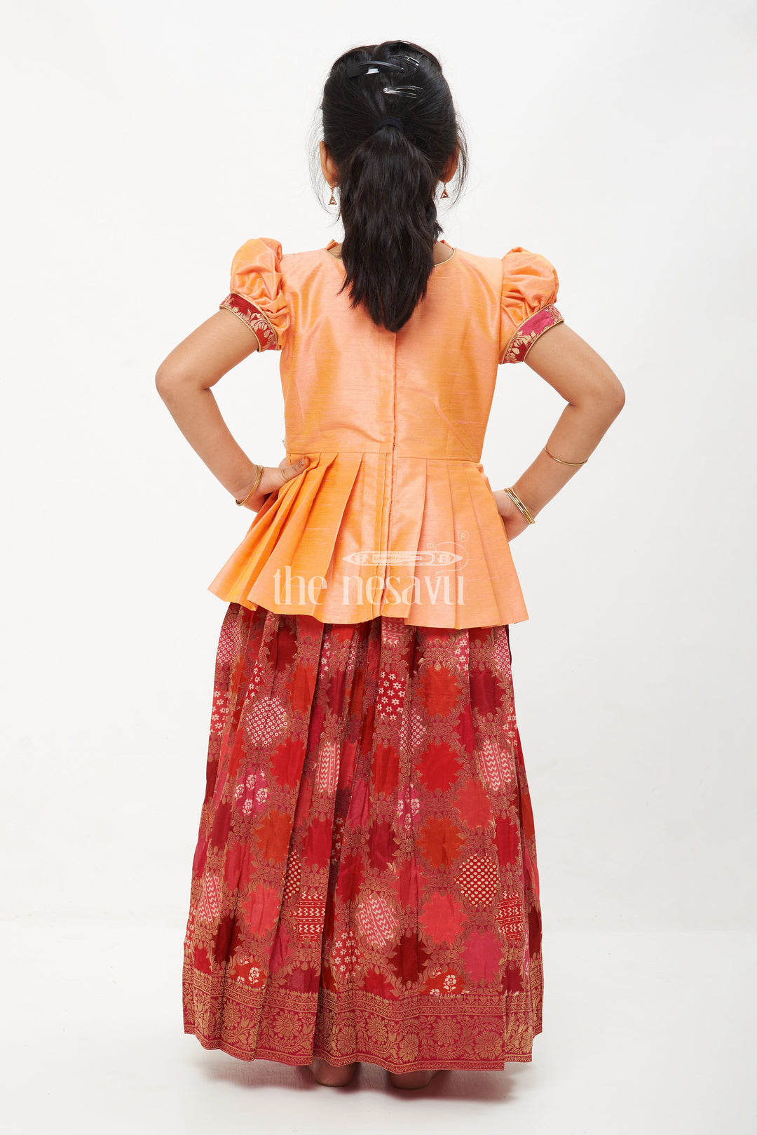 The Nesavu Pattu Pavadai Peach and Pink Viscose Silk Peplum Top with Placement Print Skirt for Girls Nesavu