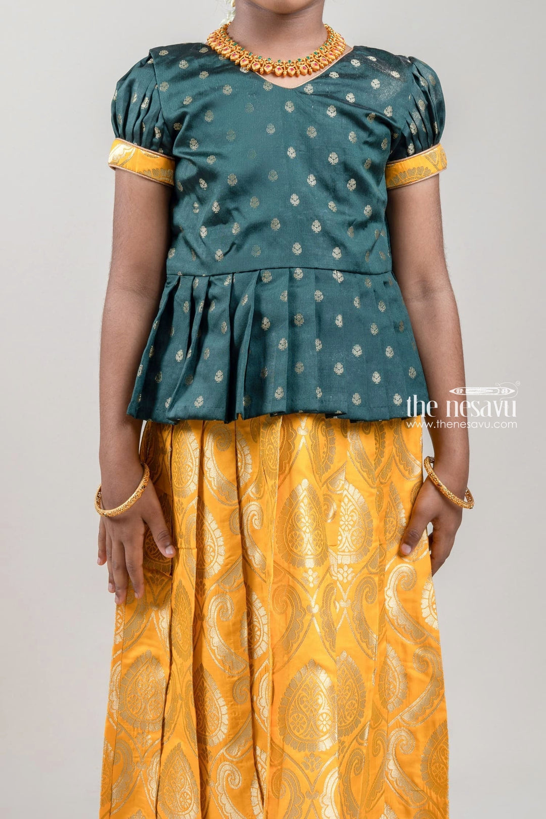 The Nesavu Pattu Pavadai Zari Butta Printed Green Silk Peplum Blouse with Knife Pleated Yellow Pattu Pavadai for Girls Nesavu Zari Butta Printed Green Silk Peplum Blouse with Knife Pleated yellow Pattu Pavadai for Girls | Shop at The Nesavu